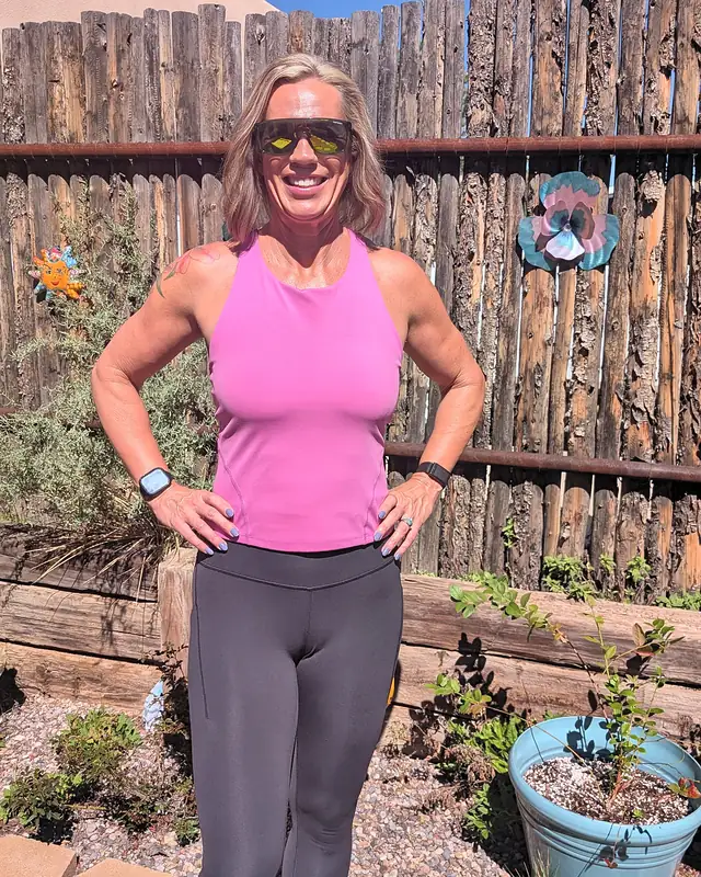 Jill smiling with her hands on her hips in her backyard