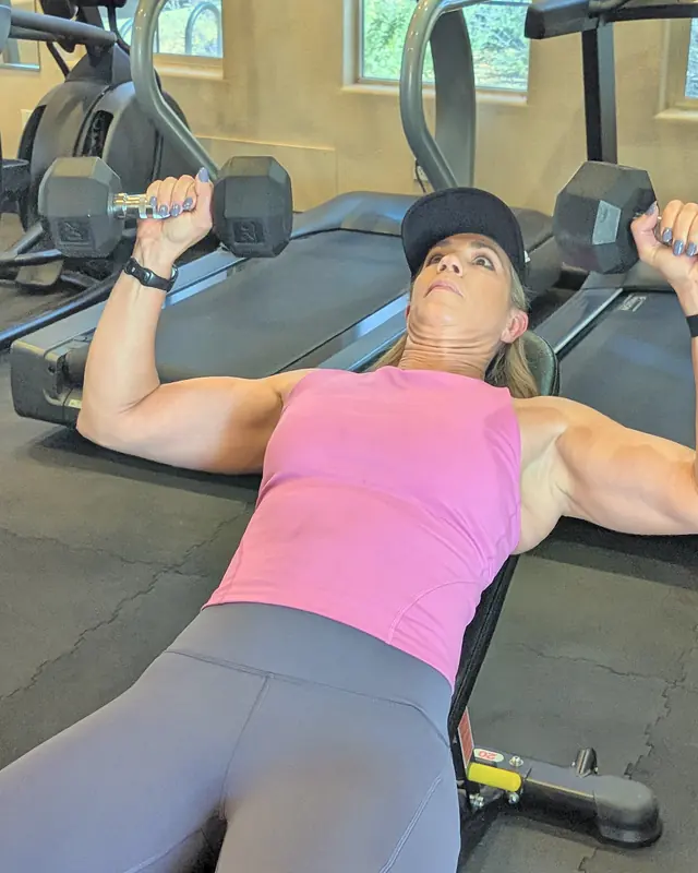 Jill doing an incline dumbbell press on a bench