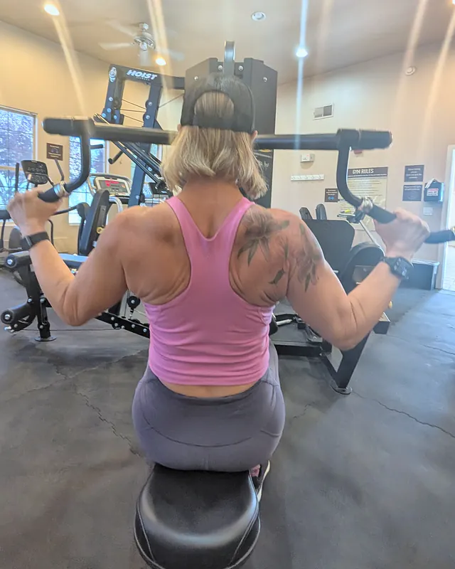 Jill from behind on the lat pulldown machine, back and shoulder muscles showing